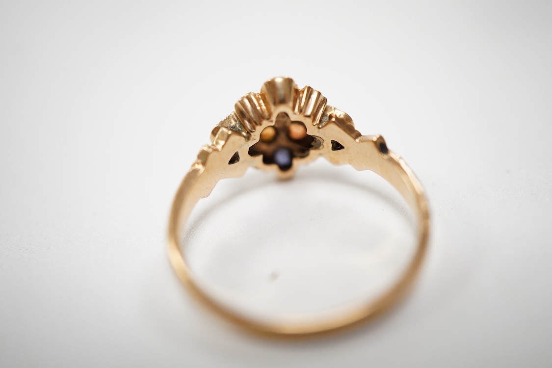 A late Victorian yellow metal, sapphire, opal and seed pearl cluster set dress ring, (one stone a paste replacement), size N, gross weight 2.2 grams.